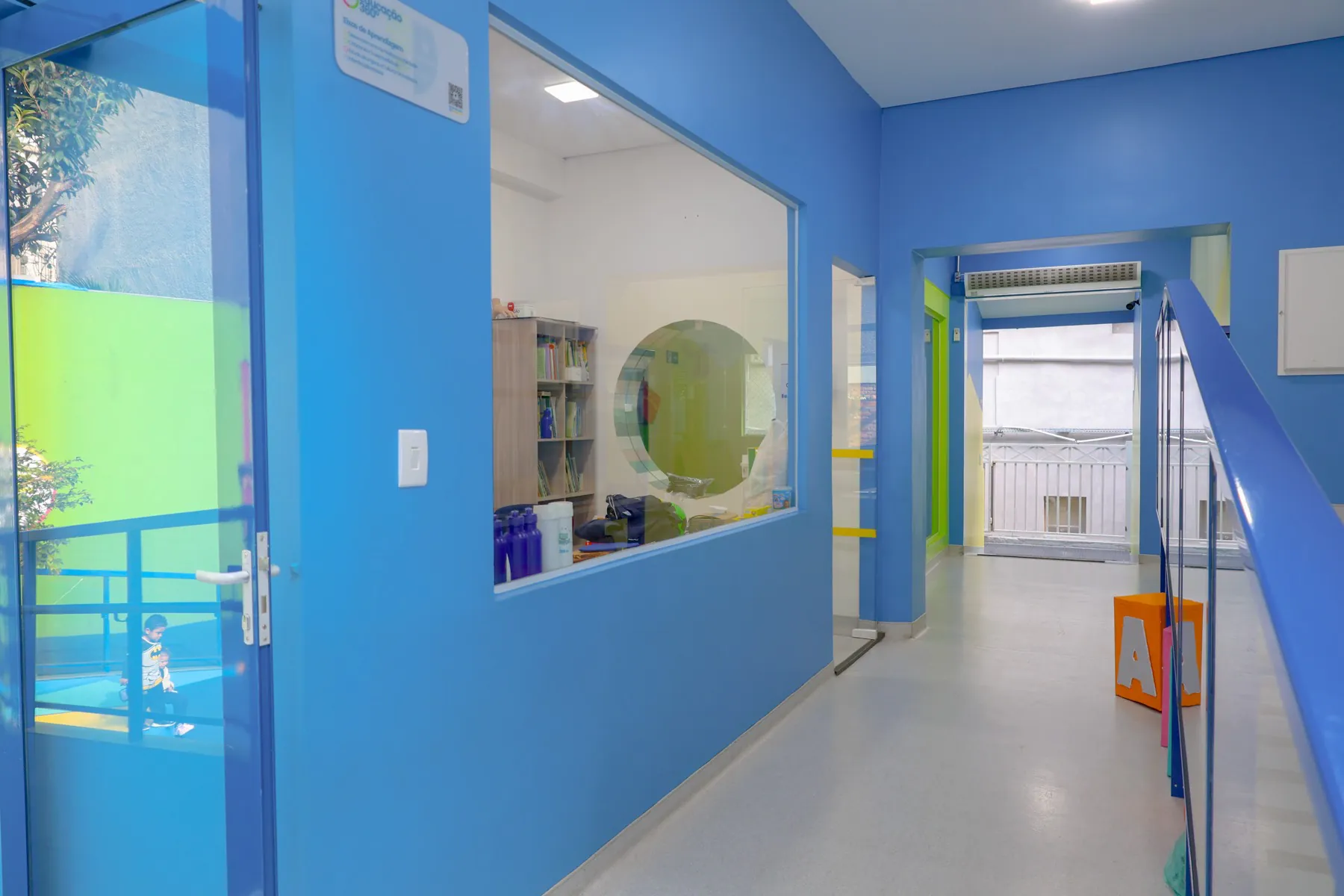 Corredor azul da ala da Educação Infantil com sala de leitura