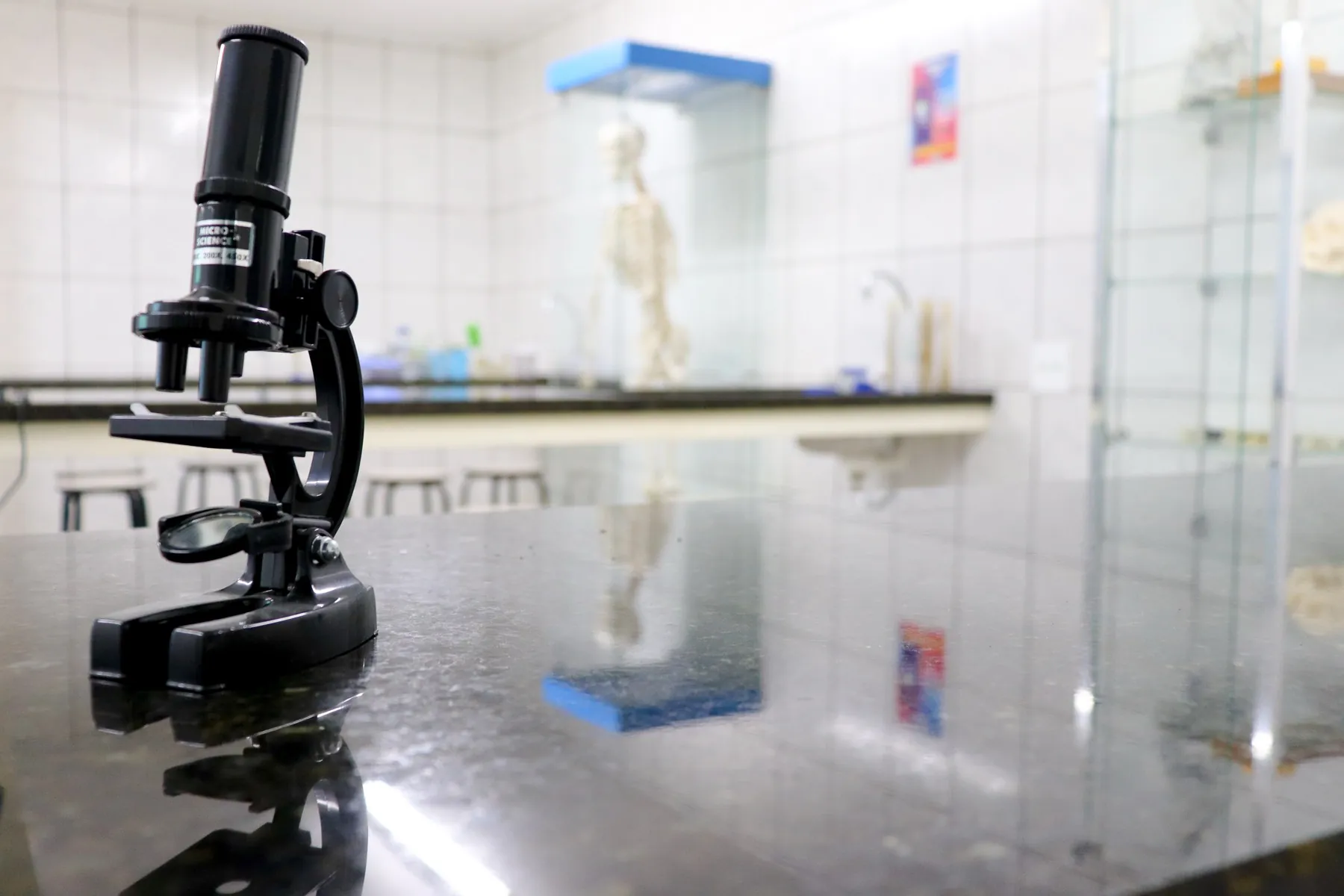 Laboratório de Ciências com microscópio em primeiro plano