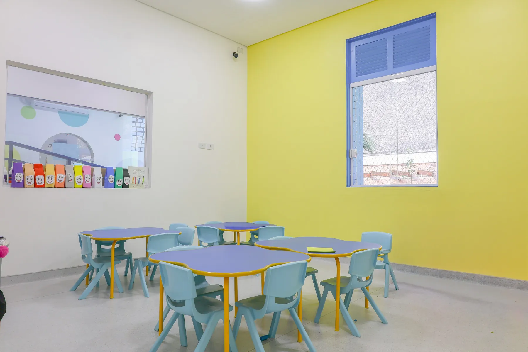 Sala da Educação Infantil com mesinhas azuis em formato de flor