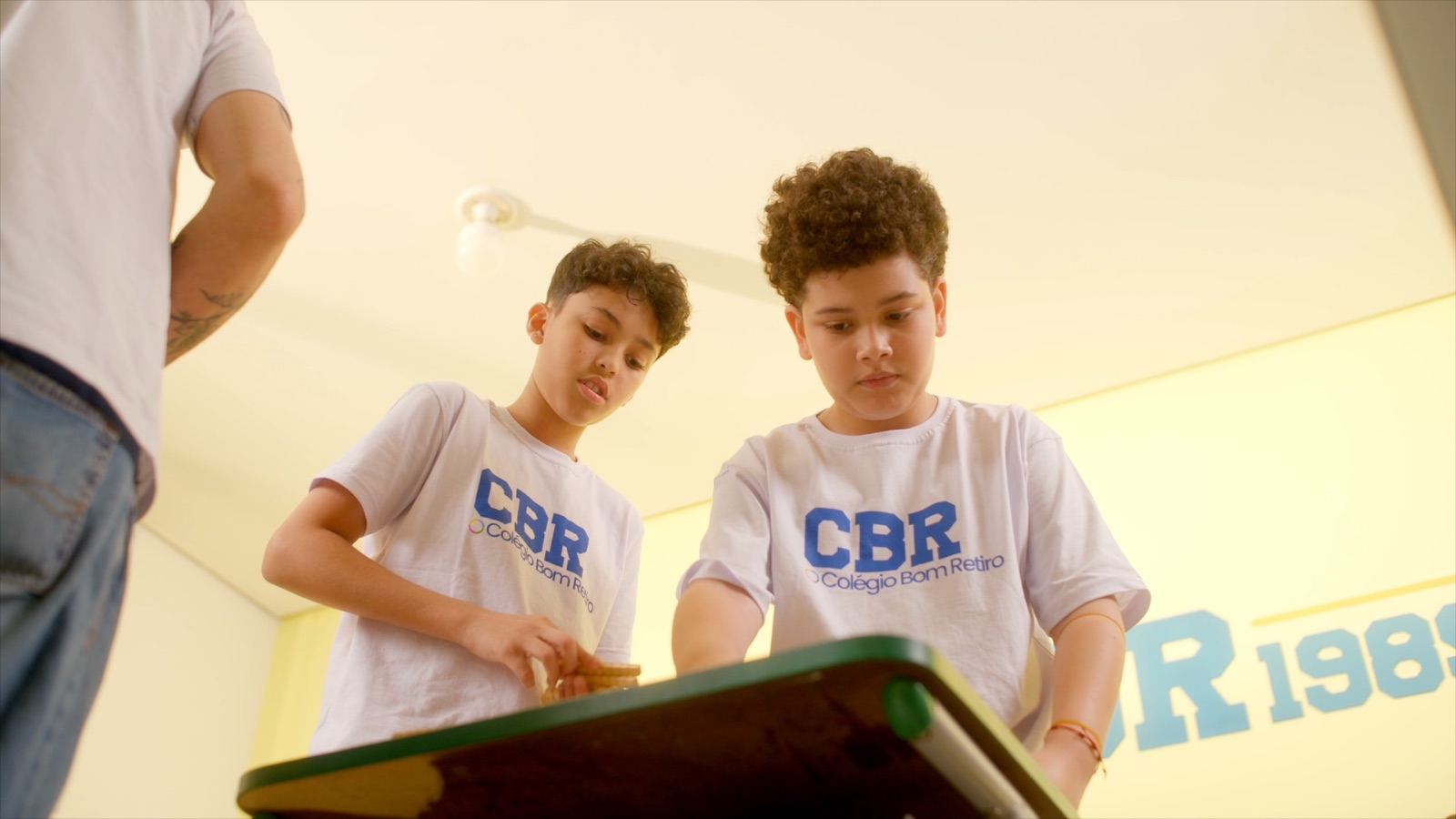 Alunos do 5º ano trabalhando juntos em um experimento na sala CBR 1989